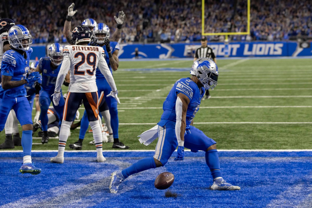David Montgomery throws the ball down flexing his arms toward the ground celebrating in the endzone
